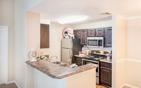 a renovated kitchen with stainless steel appliances and granite counter tops