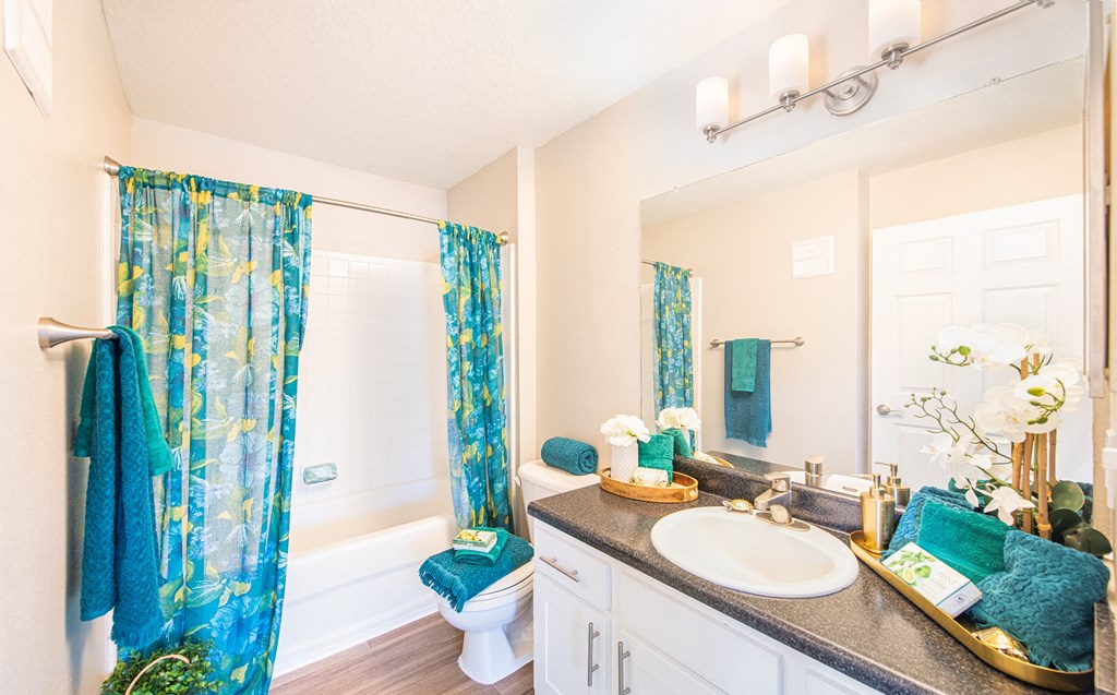 a bathroom with blue shower curtains and a sink and a toilet