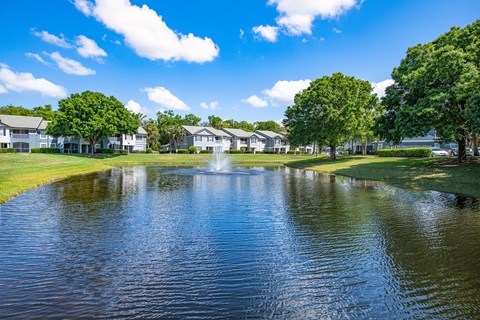 a large pond with a fountain in the middle of it
