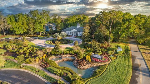 an aerial view of a park with a fountain and a house