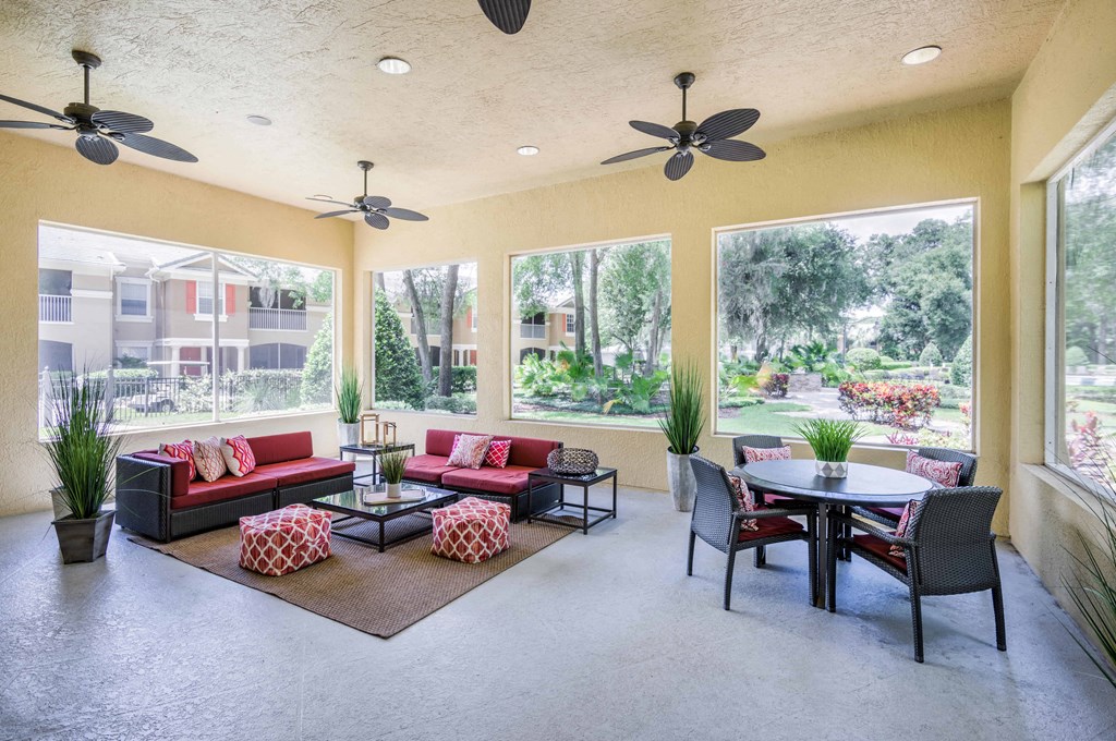 a living room with couches and a table with chairs and large windows