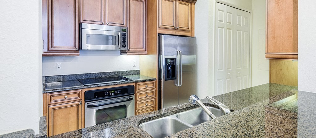 a kitchen with granite counter tops and stainless steel appliances