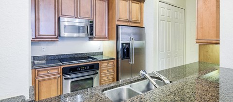 a kitchen with granite counter tops and stainless steel appliances