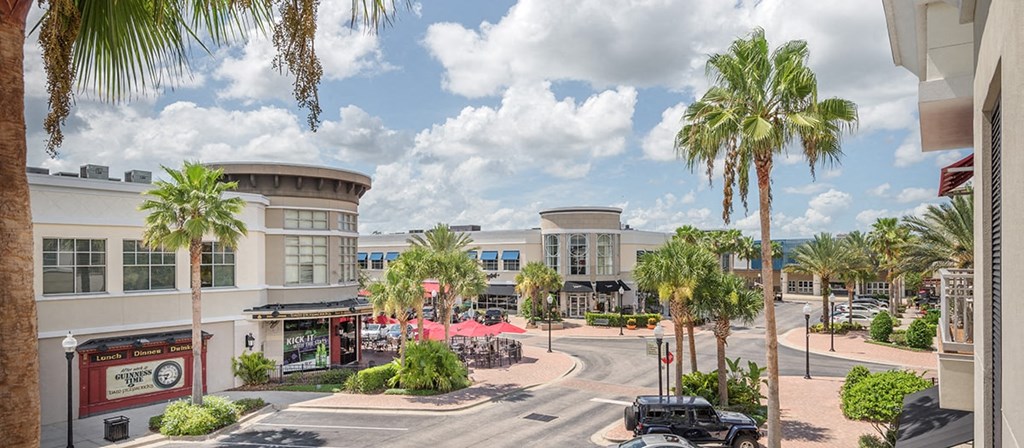 a city street with buildings and palm trees