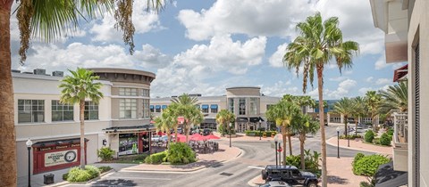 a city street with buildings and palm trees