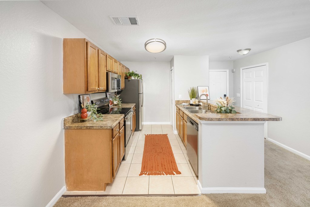A kitchen with a white island and wooden cabinets.