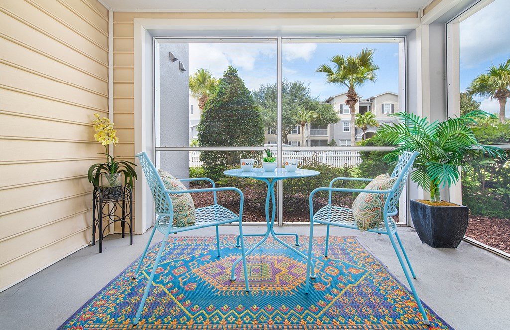 a patio with a table and chairs and a large window