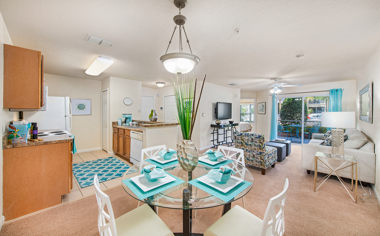 a living room and dining room with a glass table and chairs