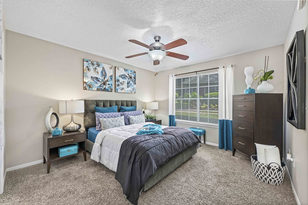 a bedroom with a bed and a ceiling fan