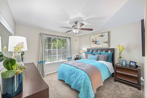a bedroom with a bed and a ceiling fan