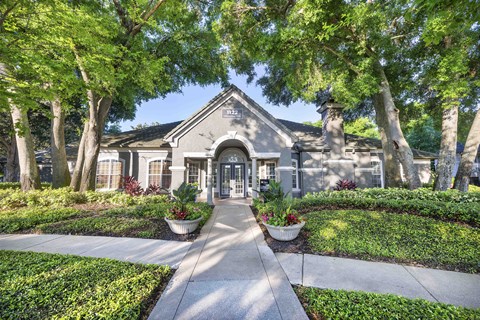 the front entrance of a house with trees and plants