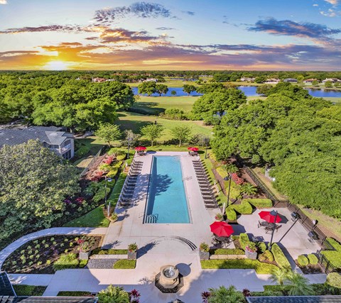 an aerial view of a pool and a backyard with trees