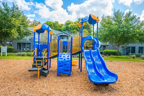 a playground with a blue and yellow swing set