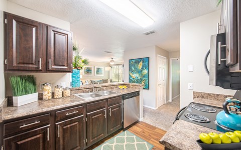 a kitchen with wooden cabinets and granite counter tops and a sink