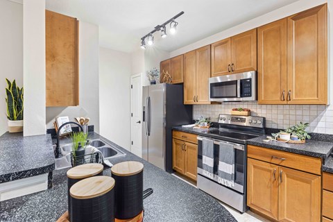 a kitchen with wooden cabinets and stainless steel appliances