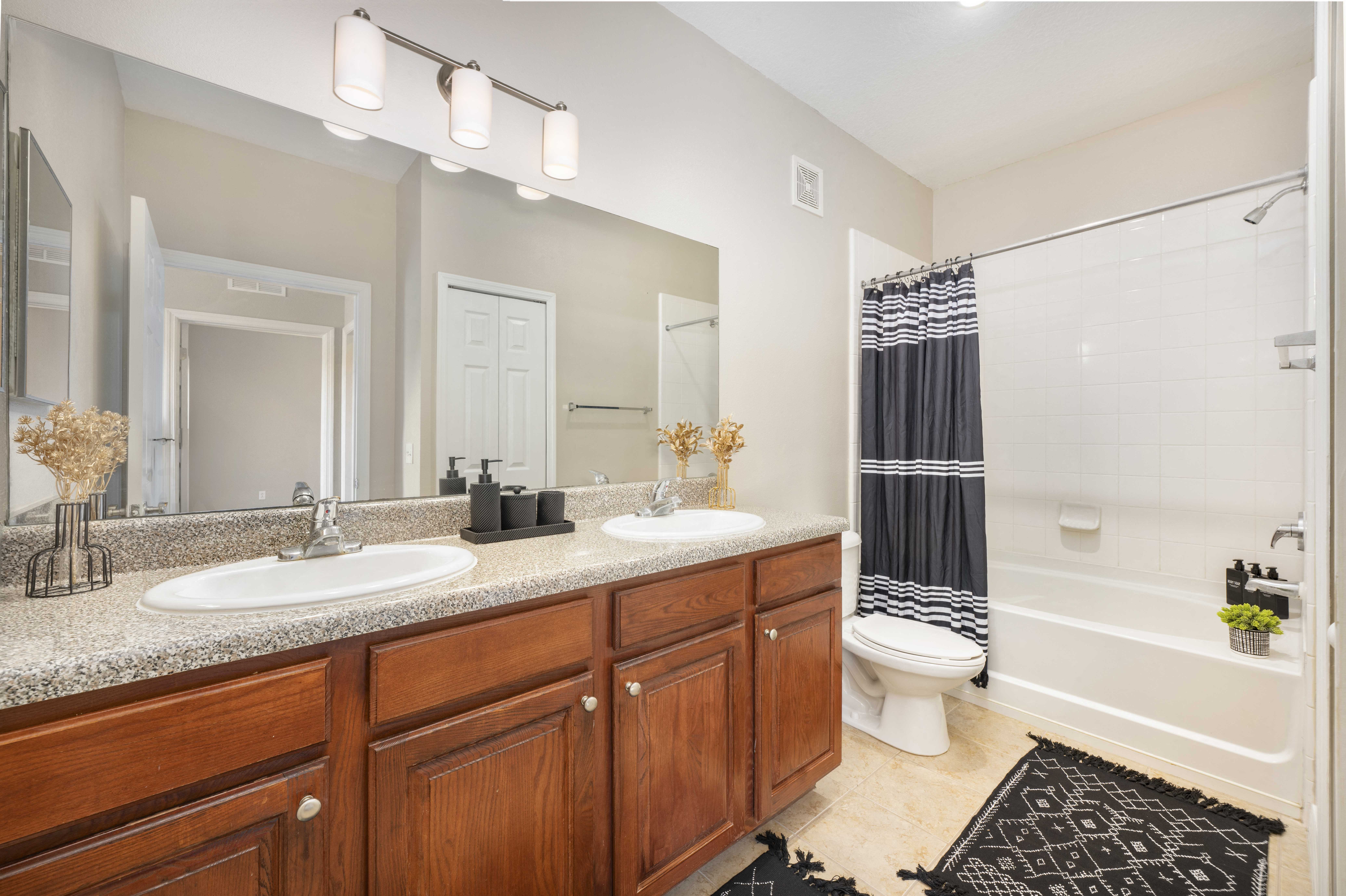 a bathroom with two sinks and a shower and a toilet