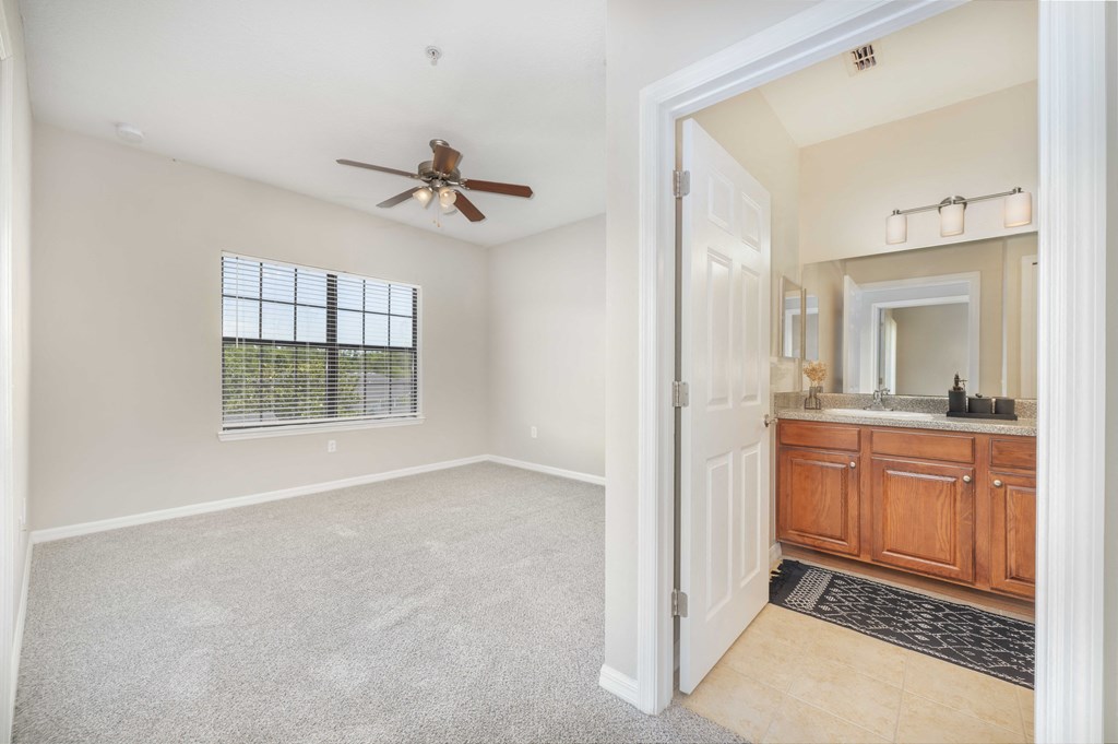 an empty bathroom with a ceiling fan and a sink