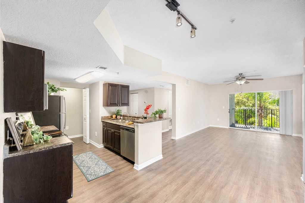 A kitchen with a refrigerator, sink, and countertop.