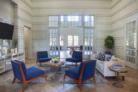 a living room with blue chairs and a white couch