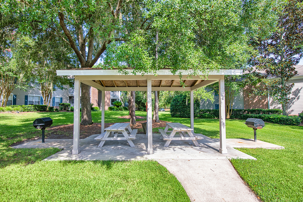 a picnic pavilion with two picnic tables in a park