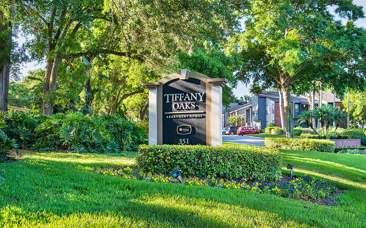 a sign for the trenary oaks apartments on a lawn