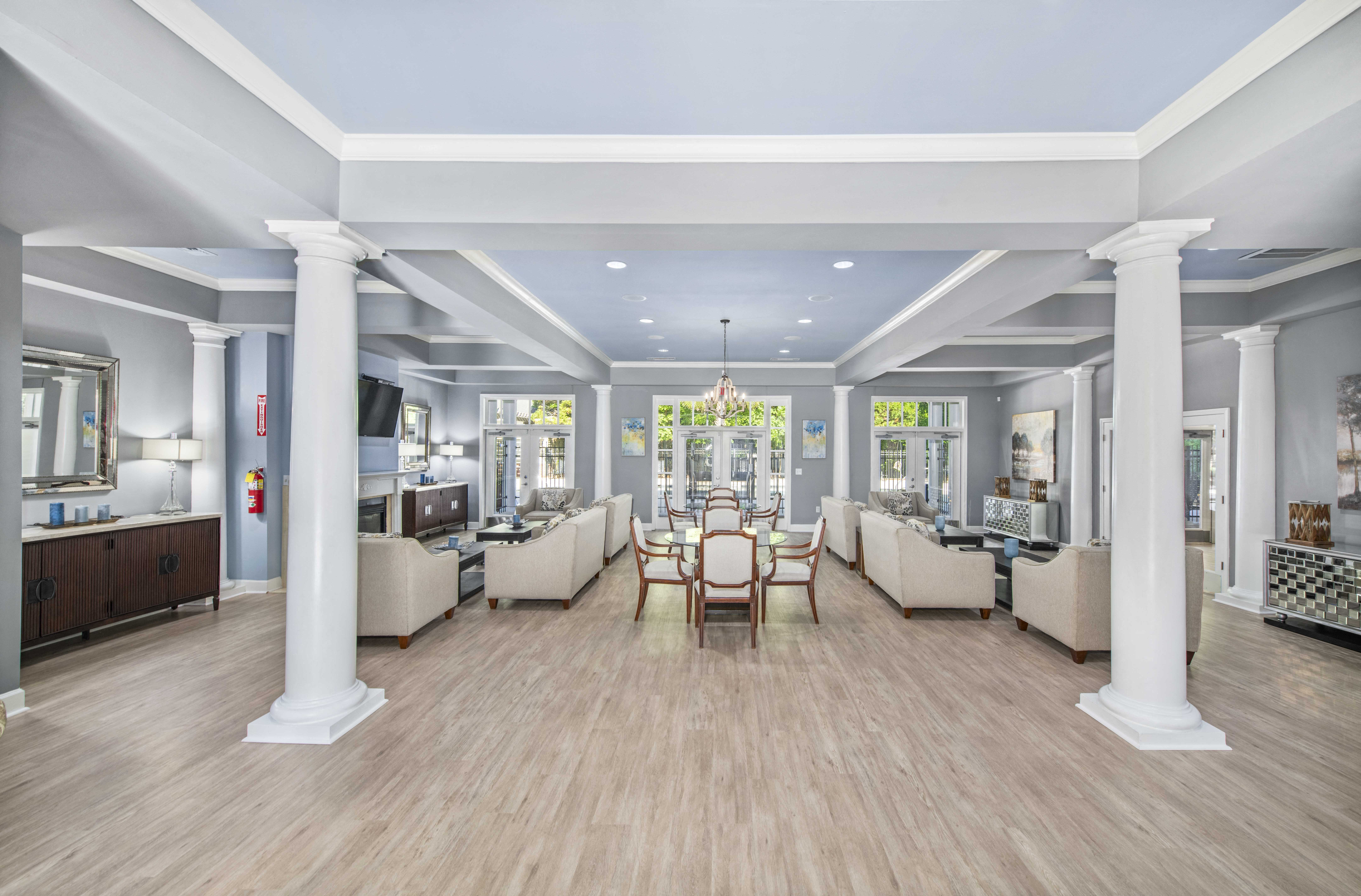 a dining room with white pillars and a table with chairs
