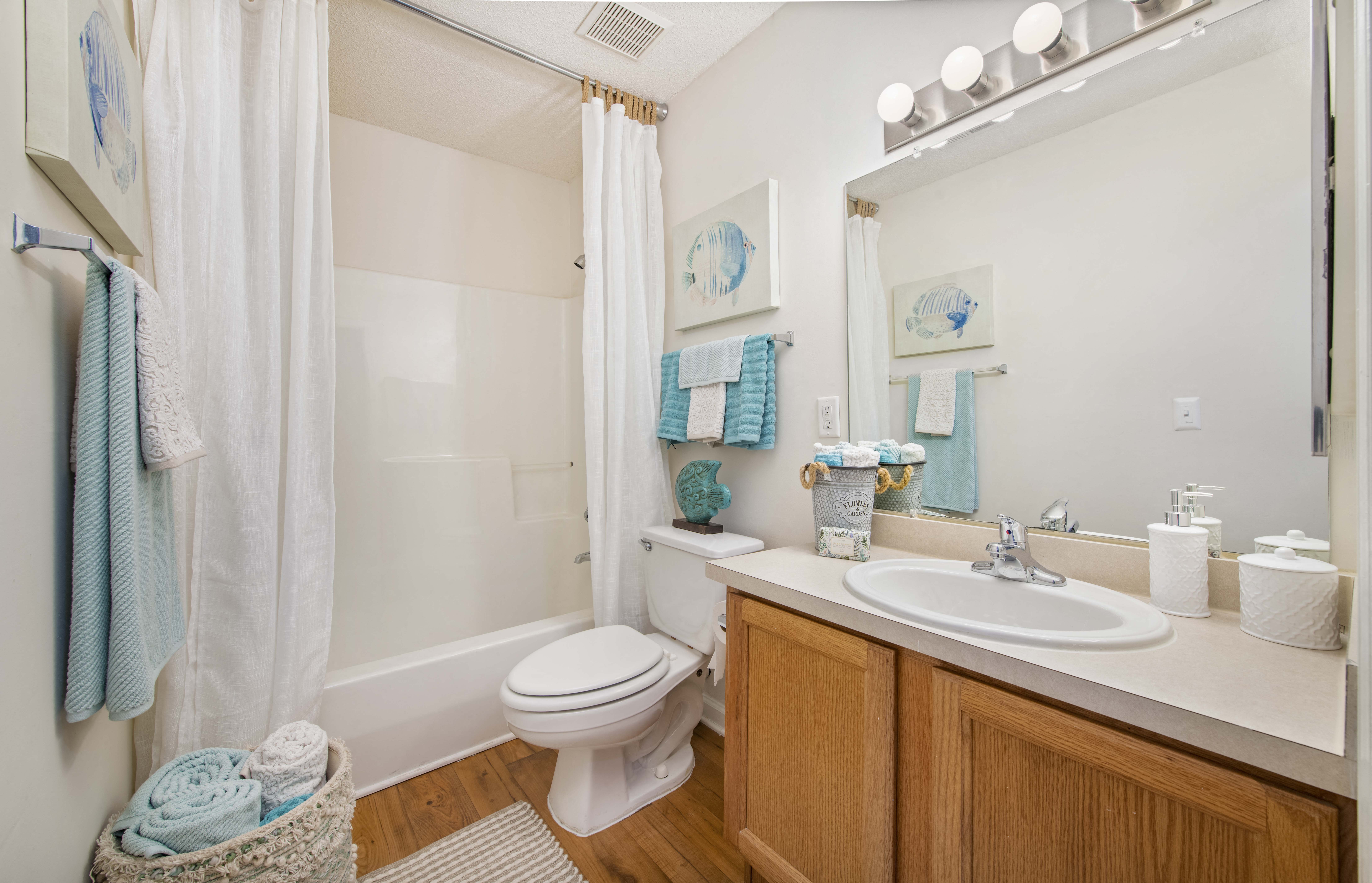 a bathroom with a toilet sink and shower and a mirror