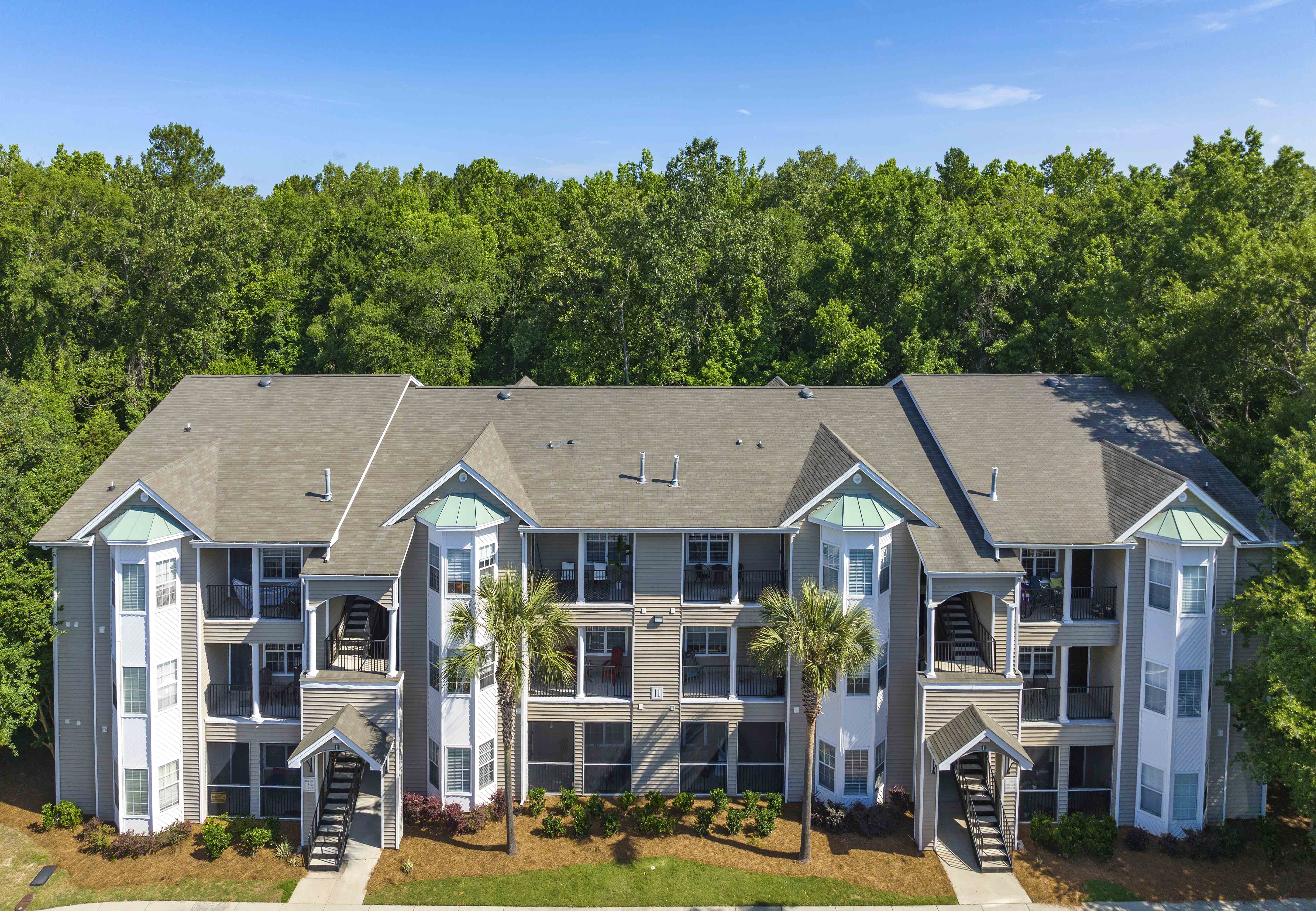 an aerial view of a building with palm trees