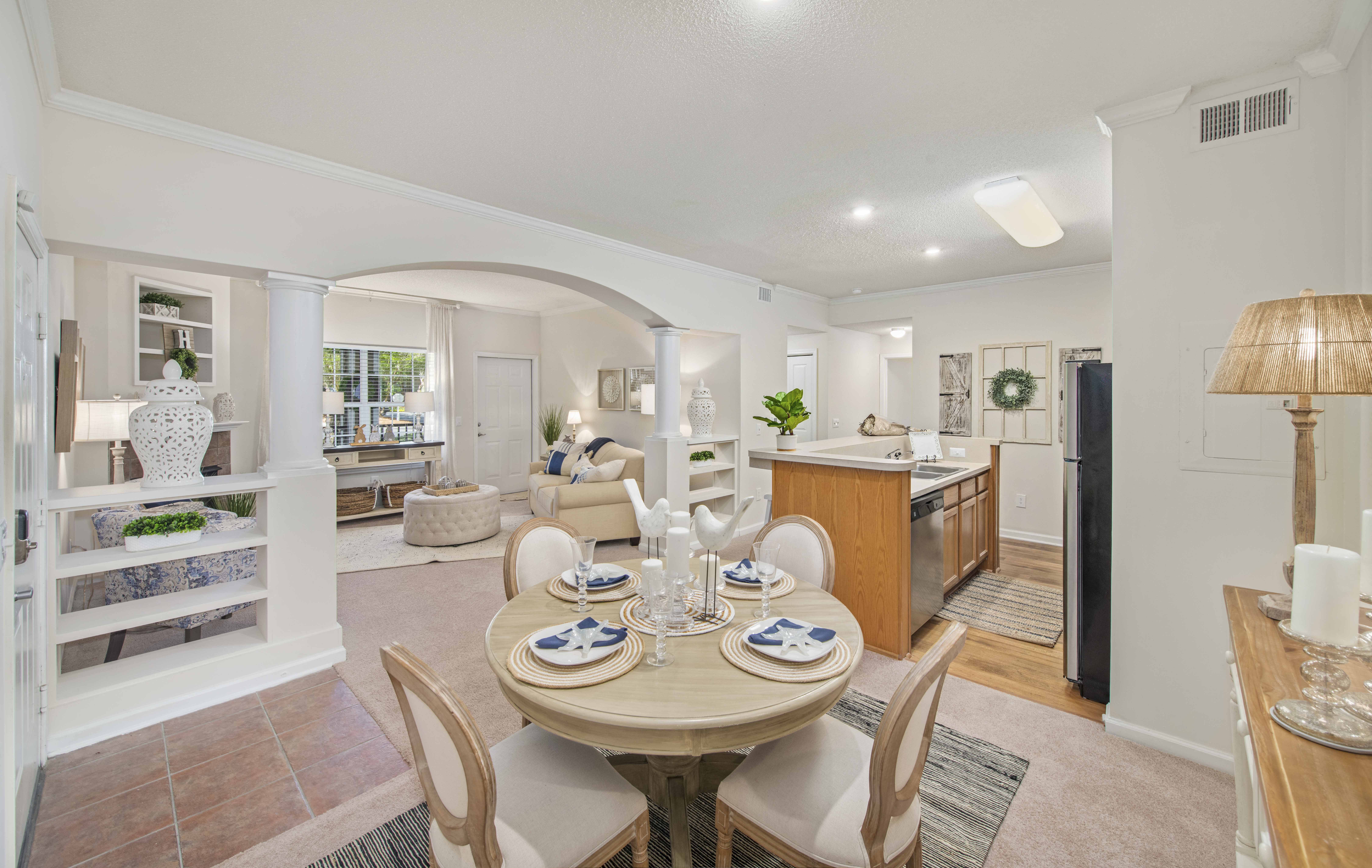 a living room with a dining room table and a kitchen