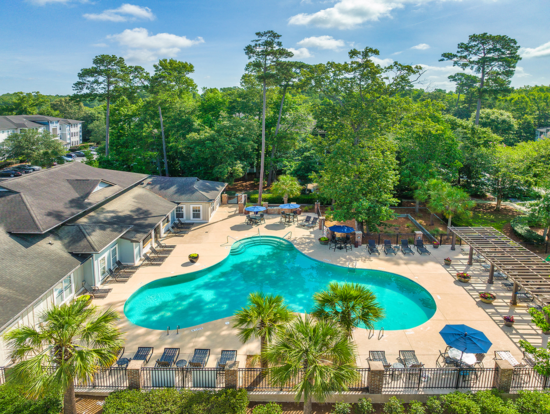 an aerial view of a resort style swimming pool with palm trees