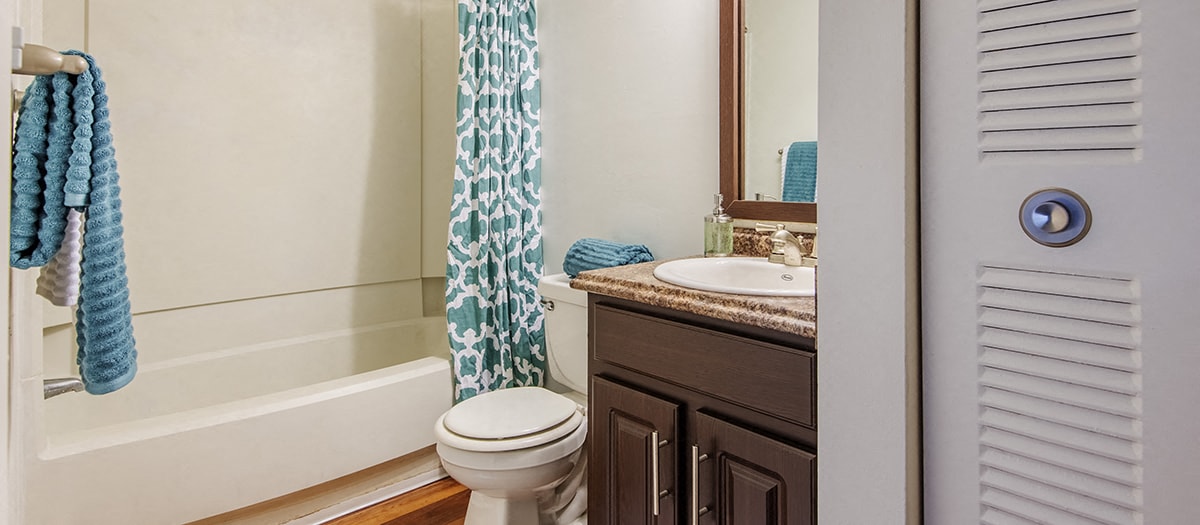a bathroom with a toilet and a sink and a shower