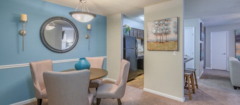 a dining room with a table and chairs and a mirror