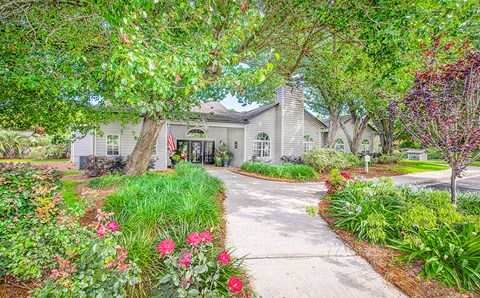 the front of a house with a driveway and trees