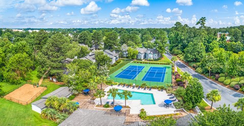 an aerial view of a tennis court and a pool with a tennis scoreboard and a