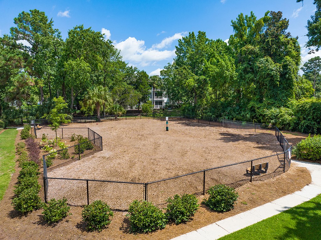 a park with a fenced in area and trees