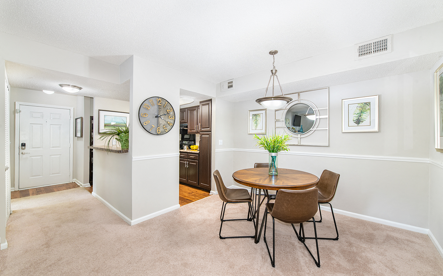 a dining room with a table and chairs and a wall clock
