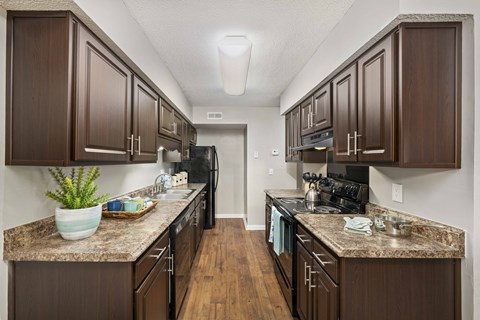 a kitchen with dark wood cabinets and granite counter tops