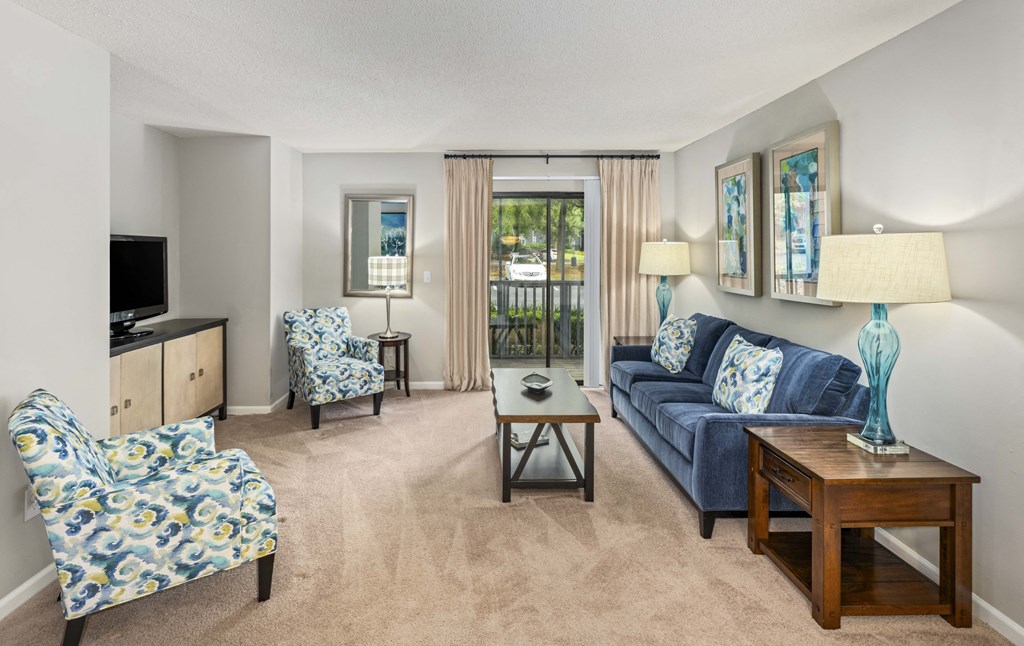 a living room with a couch and chairs and a television