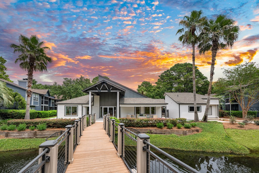 A house with a wooden deck overlooking a pond.