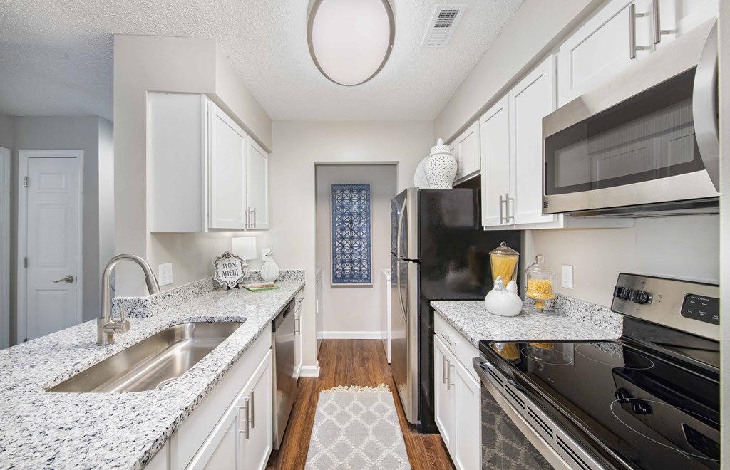 A kitchen with granite countertops and stainless steel appliances.
