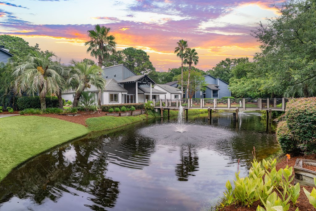 A beautiful house with a pond in front of it.