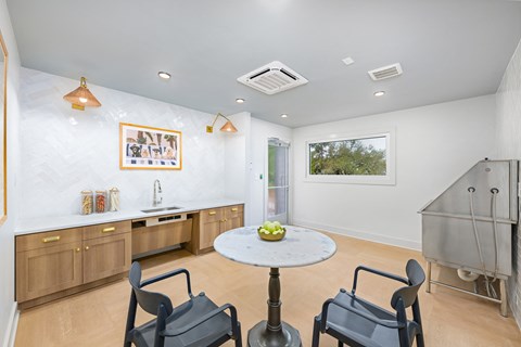 A kitchen with a table and chairs.