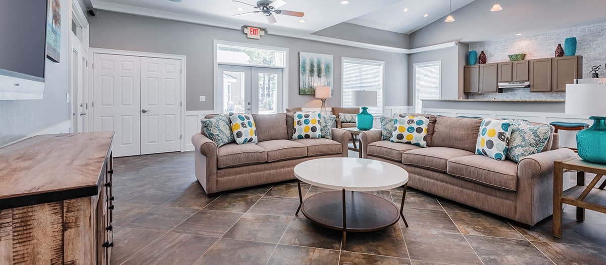 a living room and kitchen with couches and a table