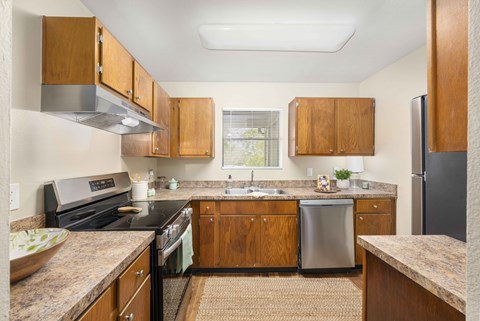 A kitchen with wooden cabinets and a granite countertop.