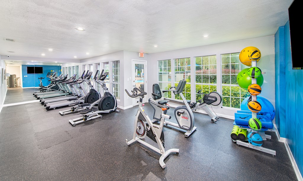 a gym with cardio machines and weights on the floor