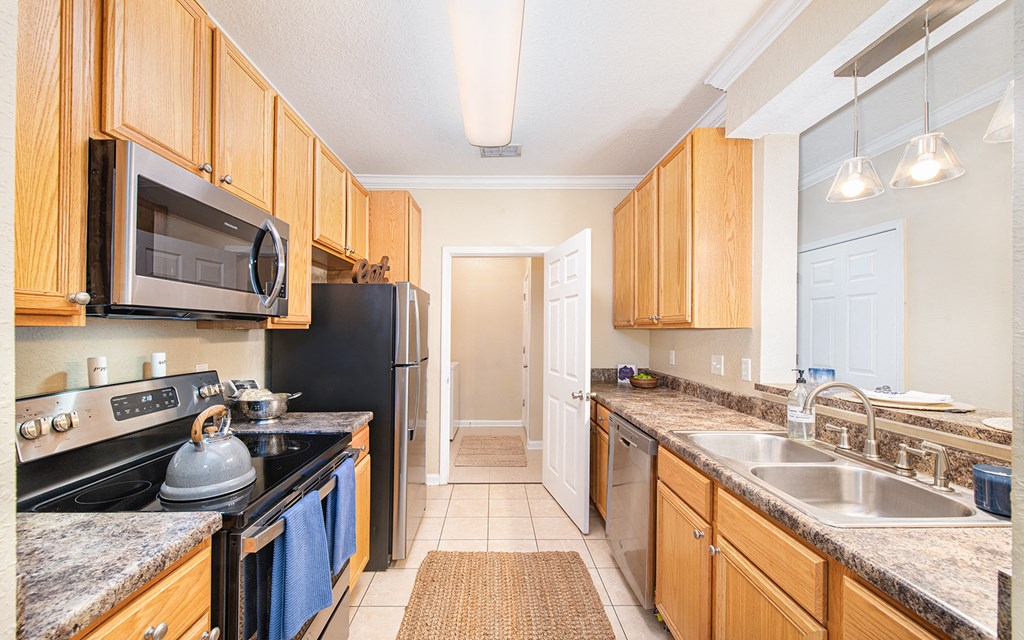 a kitchen with granite counter tops and stainless steel appliances and wooden cabinets