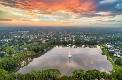 a sailboat on a lake in the middle of a city at sunset