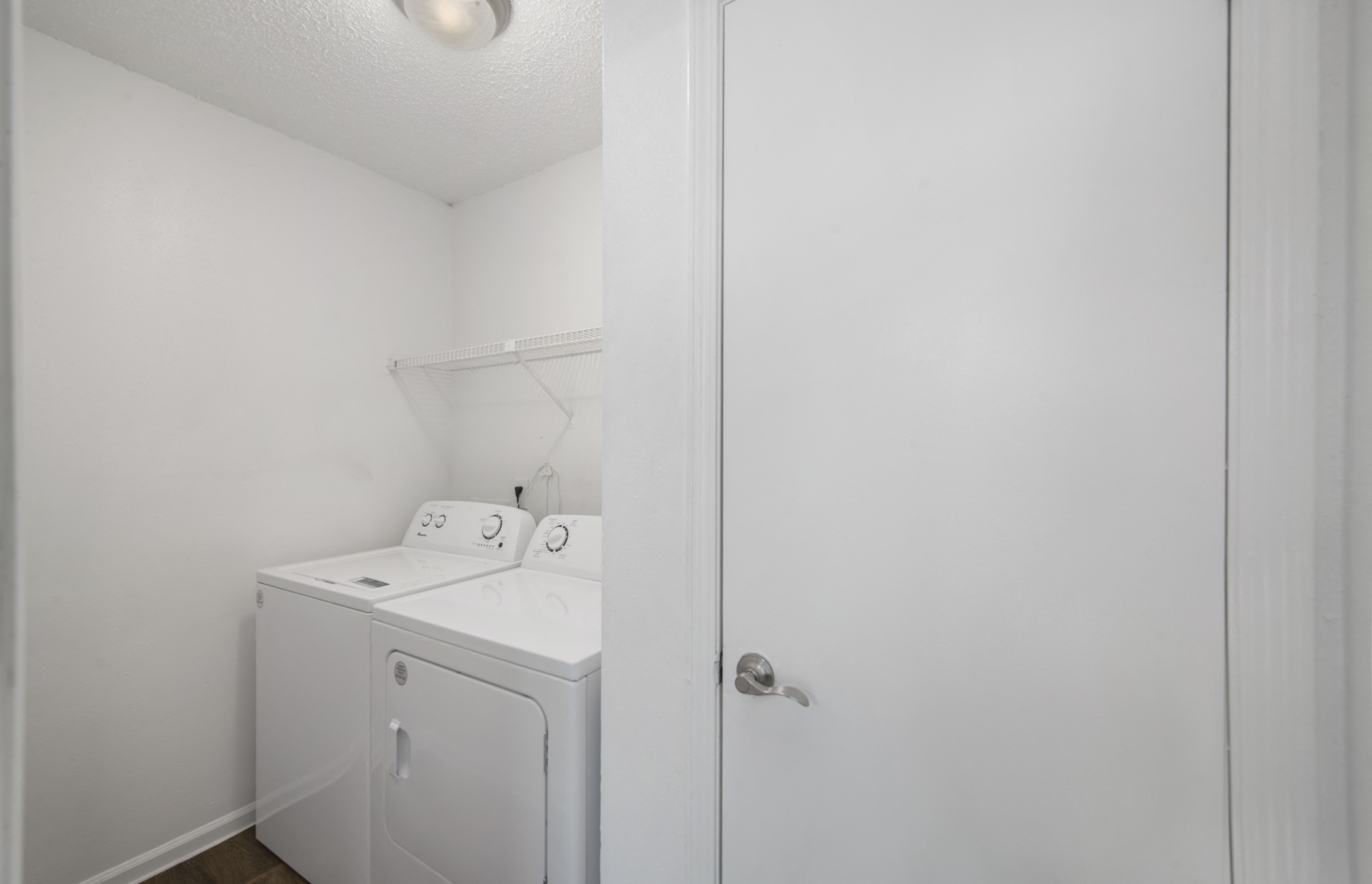 an empty laundry room with a washer and dryer in it