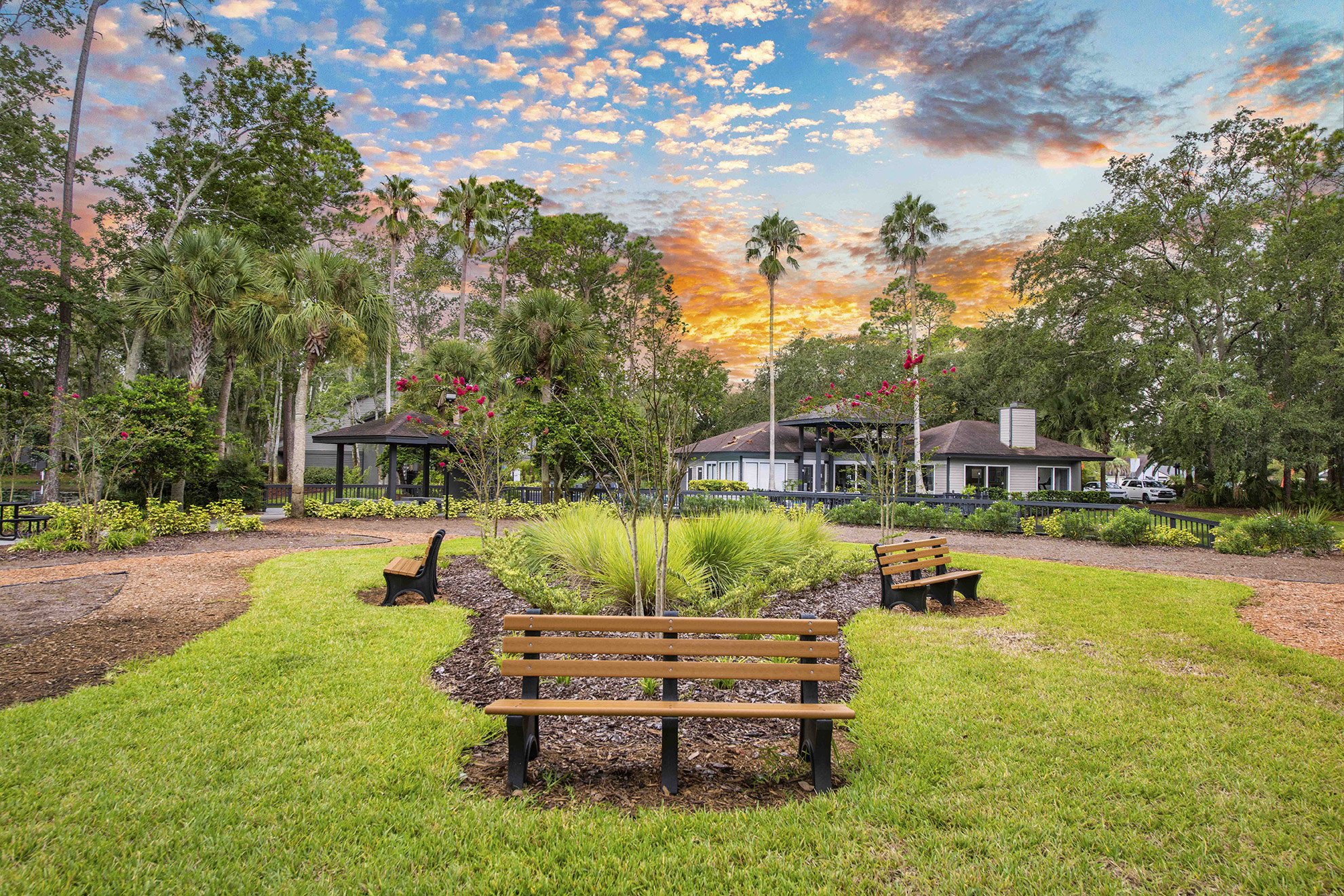 two benches in a park with a house in the background