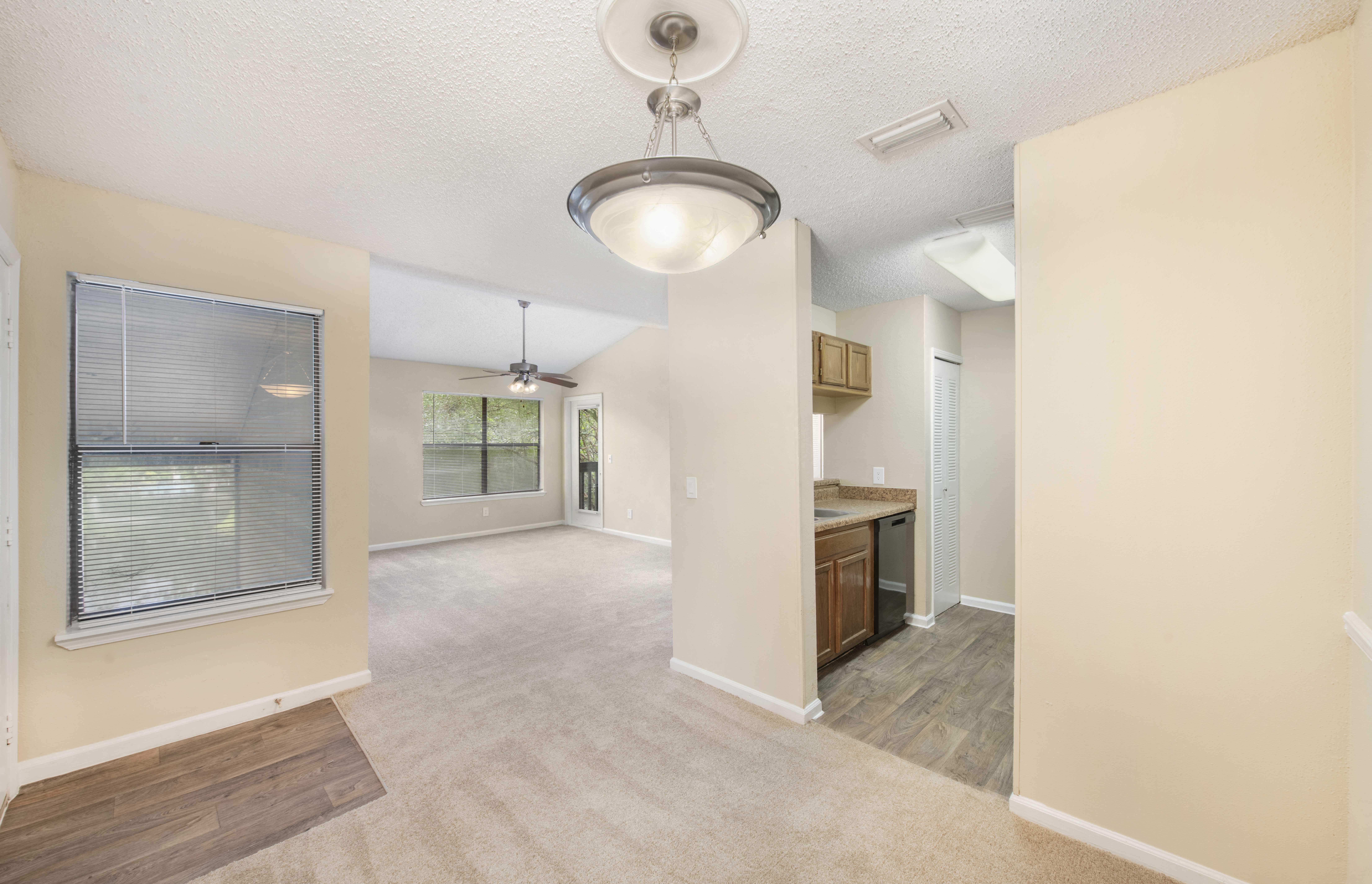an empty living room and kitchen with a large window
